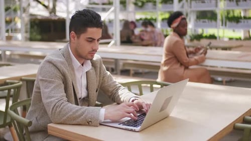 Businessman Working on Laptop in Cafe