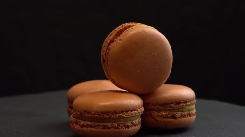 Hand Stacking Brown Macarons Close Up