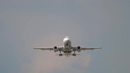 Airplane Landing Against Cloudy Blue Sky