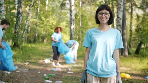 Modern Young Woman Eco-activist Turning To Camera in Forest Smiling Outside