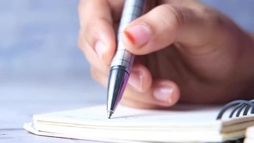Close Up of Man Hand Writing on Notepad
