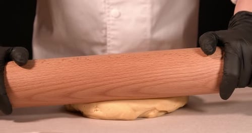 Hands rolling dough for baking close up
