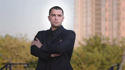 Man in Suit Stands with Arms Crossed