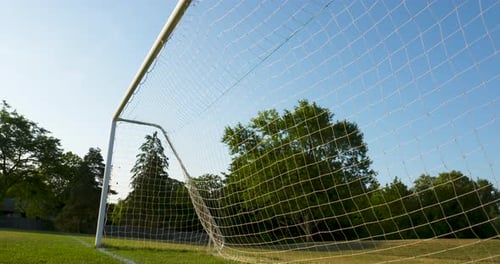 Soccer Goal Net on Green Field with Blue Sky