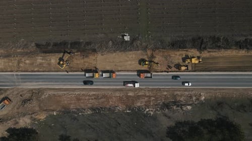 Excavator Digging Ground and Load It Into Dump Truck on Road