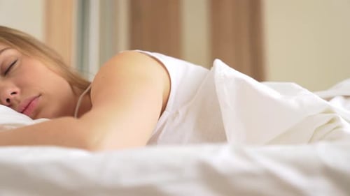 Woman Waking Up in Bed Smiling