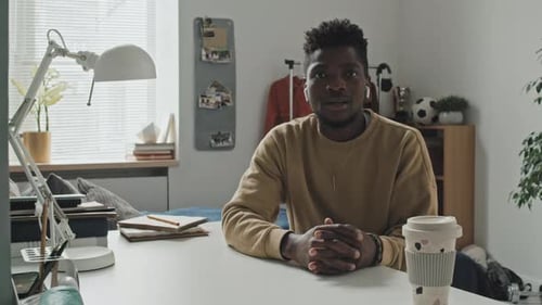 Man Sitting at Home and Talking on Camera via Video Call
