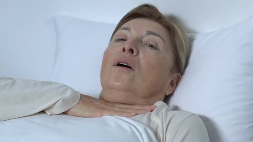 Lady Patient respirant à peine dans son lit d'hôpital, tendant la main pour obtenir de l'aide,