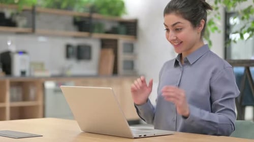Young Adult Video Calling on Laptop in Office