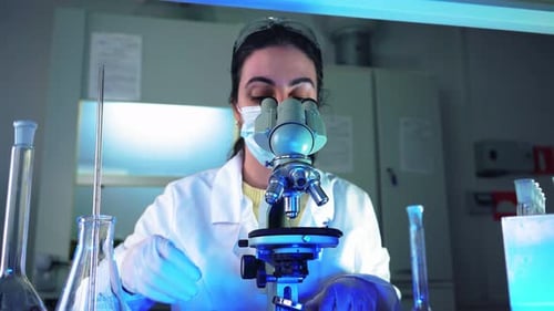 Woman Scientist Works with Microscope in Lab