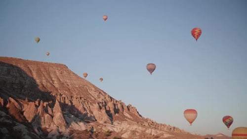 Hot Air Balloons Floating Over Rocky Desert Landscape