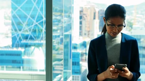 Professional Woman Uses Smartphone in Modern Office