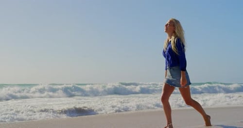 Woman Walking Barefoot on the Beach in Summertime