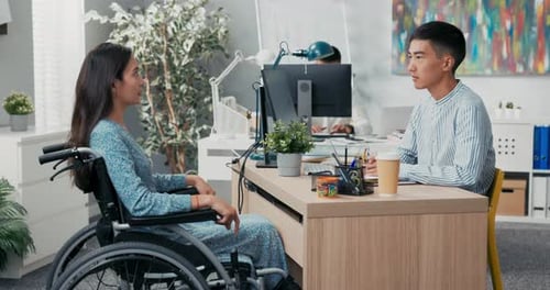 Job Interview with Disabled Woman in Wheelchair Stern Male Boss of AsianKorean Beauty Asks Questions