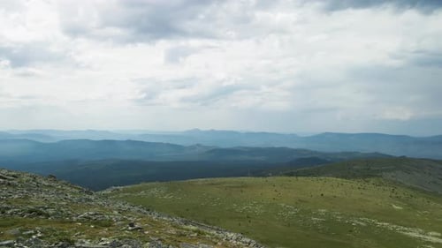 View from the height of the mountain range to the green forest