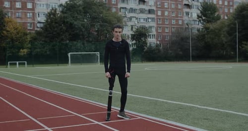 Determined Athlete with Prosthetic Leg on Running Track