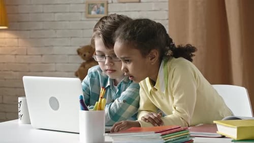 Children Using Laptop for Schoolwork at Home