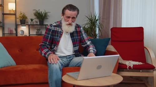 Senior Man Chatting on Laptop in Living Room