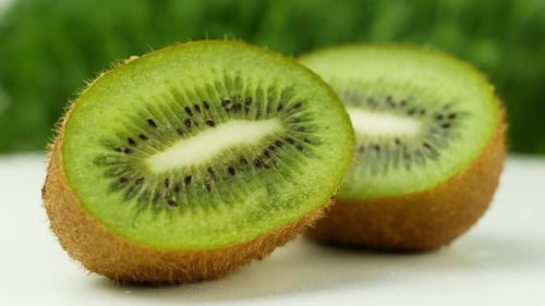 Kiwi juicy tropical fruit rotating 360 slow motion on a green background.