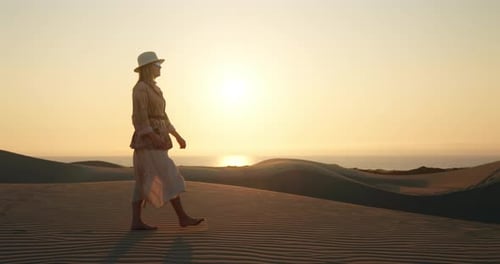 Lonely Girl Walking Barefoot on Rippled Sand Dune in Desert