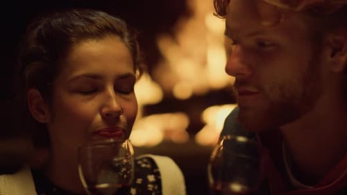 Young Couple Drinking Wine by a Fire