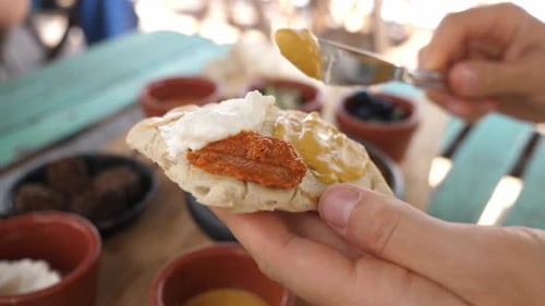 Person Spreading Topping on a Piece of Bread