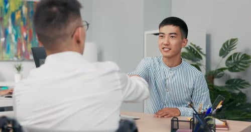 Zwei Männer treffen sich am Morgen im Firmenbüro zum Interview Behinderter Junge kommt im Rollstuhl an