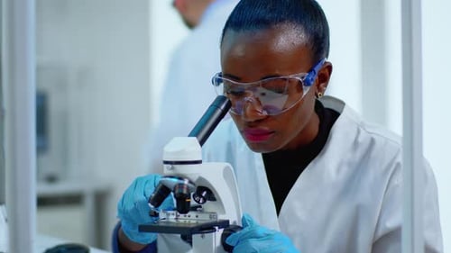 Close Up of Black Woman Looking in Microscope