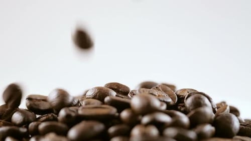 Coffee Beans Falling onto Pile Close Up