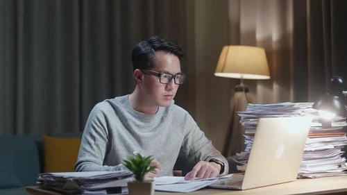 Focused Young Adult Working Late at Home Desk