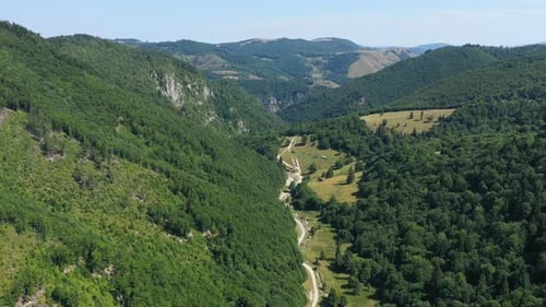 Flug über ein tiefes Tal und Laubwald und Kalksteinfelsen. Luftaufnahme