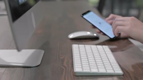 Nahaufnahme von Händen junger Frauen mit Handy und Tastatur