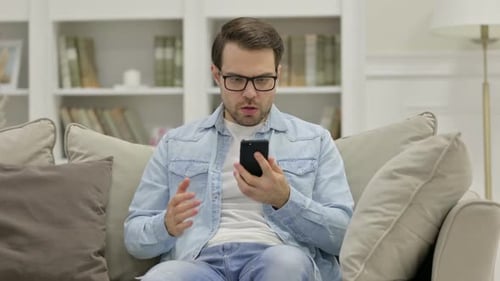 Man Reacts to Phone, Upset, Then Triumphant