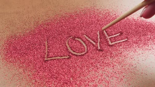 Writing the word love in red glitter