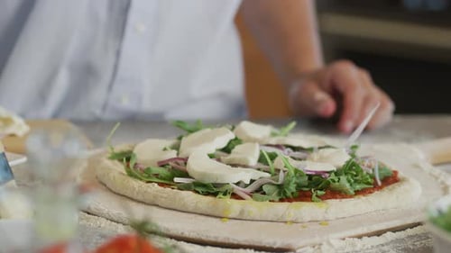 Preparing Delicious Pizza with Arugula and Mozzarella