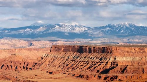 Time lapse of desert mesa and snow covered mountains