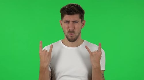 Porträt eines selbstbewussten Mannes, der eine Rock-Geste macht und das Leben genießt