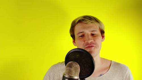 Man Talking into Microphone on Yellow Background