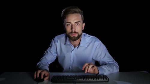 Man with a Excitedly Looking at a Computer Monitor. Studio