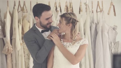 Bride and Groom Embrace in Bridal Boutique