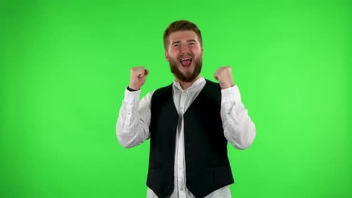 Mann schaut in die Kamera und feiert dann seinen Siegessieg auf Greenscreen.