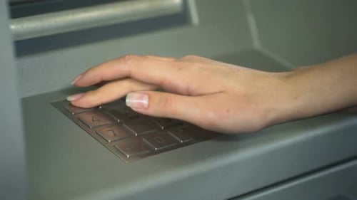 Woman Entering PIN Number to Check Bank Account and Withdraw Money From ATM