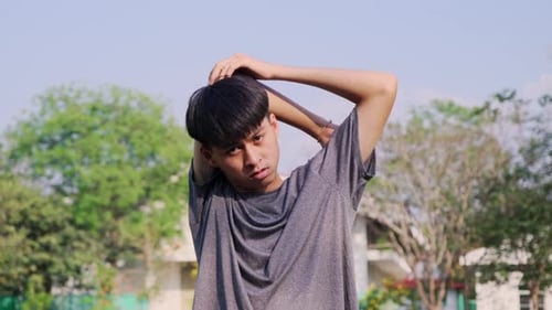 Healthy young man stretches to warm up before running in the park.