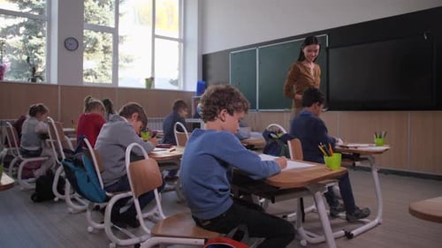 Students Writing at Desks in Classroom