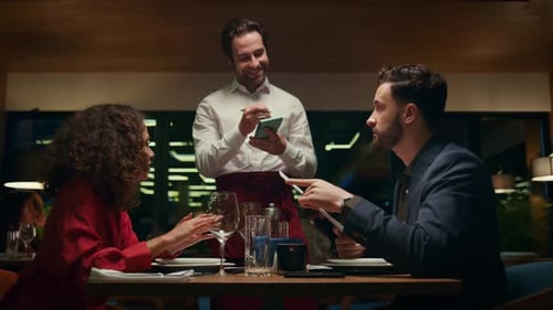 Smiling Waiter Serving Couple on Restaurant Date