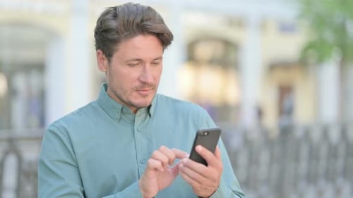 Outdoor Man Browsing on Smartphone