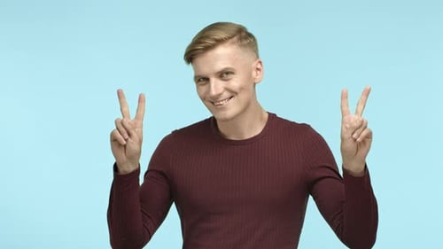 Young Adult Shows a Peace Sign and Smiles