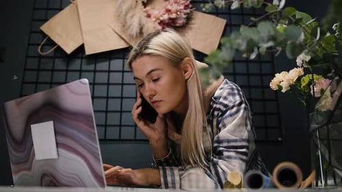 Young Creative Woman in Flower Shop Using Laptop Makes Fresh Flowers Order