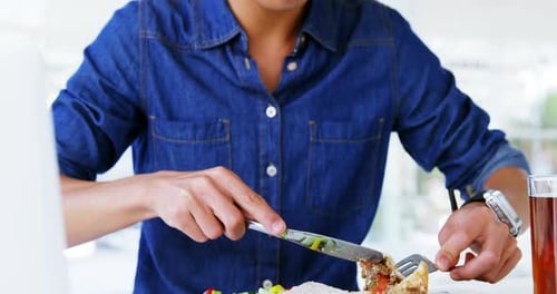 Young Adult Eating Lunch at Desk at Workplace