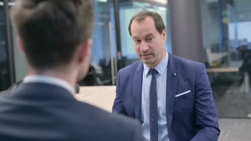 Rear View of Businessman Talking to Man in Office